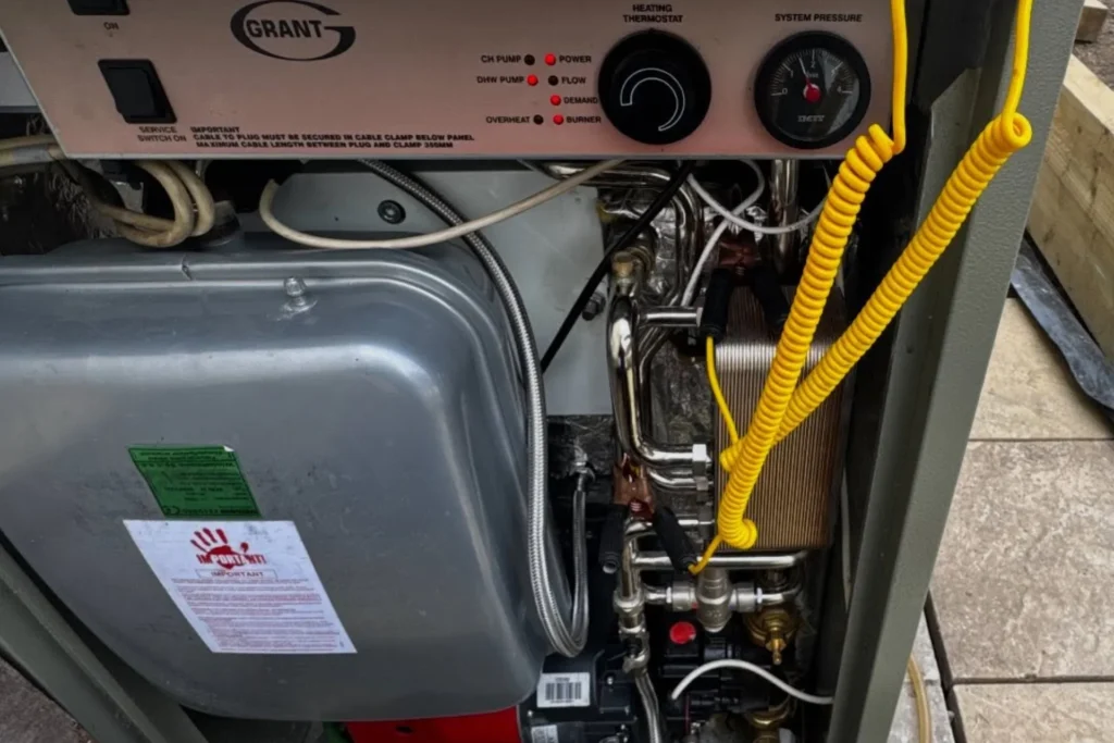 Close up of a Grant oil boiler with exposed heating components during servicing or maintenance.