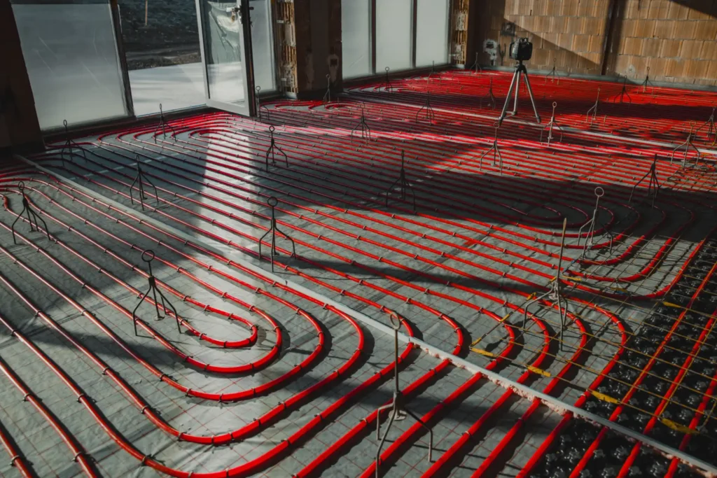 Underfloor heating pipes installed in a spiral layout across the floor of a property under construction.